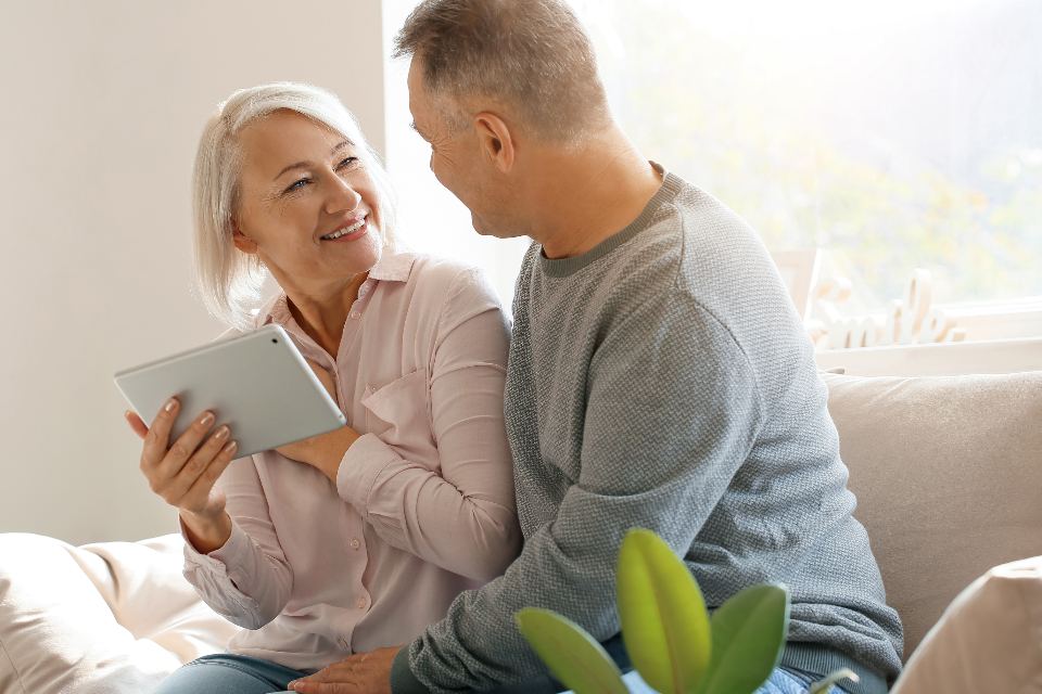 An older couple looking over information together on a tablet at home