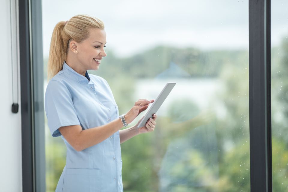 A nurse reviewing care notes on a tablet